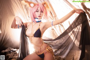 A woman with pink hair wearing a bikini and a cat ears headband.