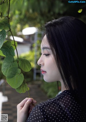 A woman with long black hair and a black shirt.