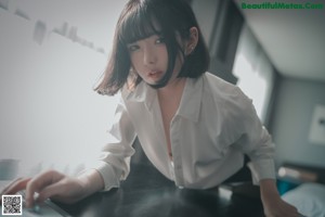 A woman in black stockings sitting on a chair.
