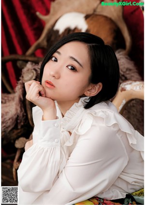 A woman in a white blouse and a black and blue dress.