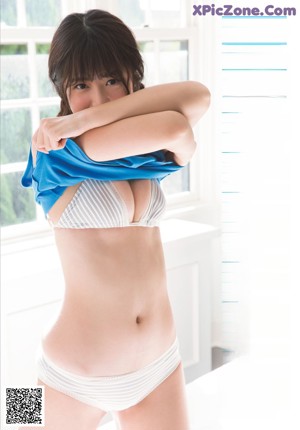A woman in a school uniform is posing for a magazine cover.
