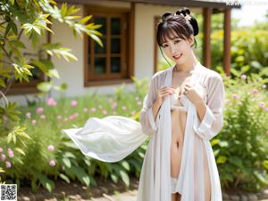 A woman in a white and pink kimono posing for a picture.