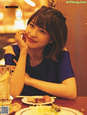 A woman sitting at a table with a plate of food.