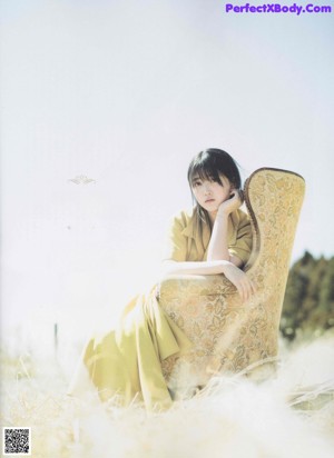 A woman with long black hair is posing for a magazine.