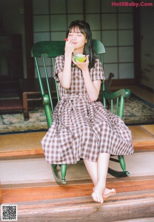 A woman in a blue kimono standing in a garden.