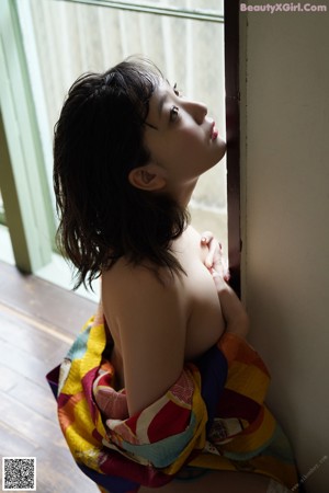 A woman in a polka dot dress leaning against a window.