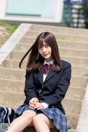 A woman in a school uniform is posing for a picture.