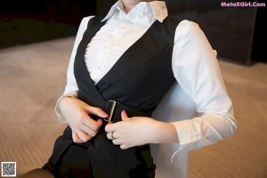 A woman in a white shirt and black stockings posing for a picture.