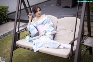 A woman in a blue and white kimono posing for a picture.