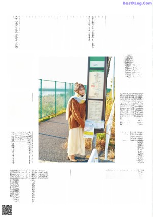 A young girl wearing a brown sweater and a yellow and blue blanket.