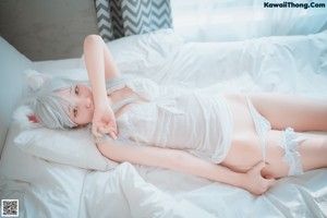 A woman sitting on top of a bed next to a window.