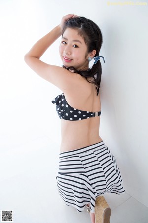 A woman in a black and white striped bikini top and shorts.