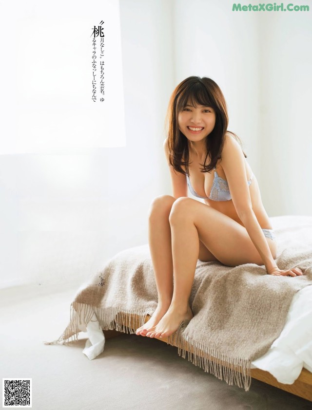 A woman sitting on top of a bed in a bedroom.