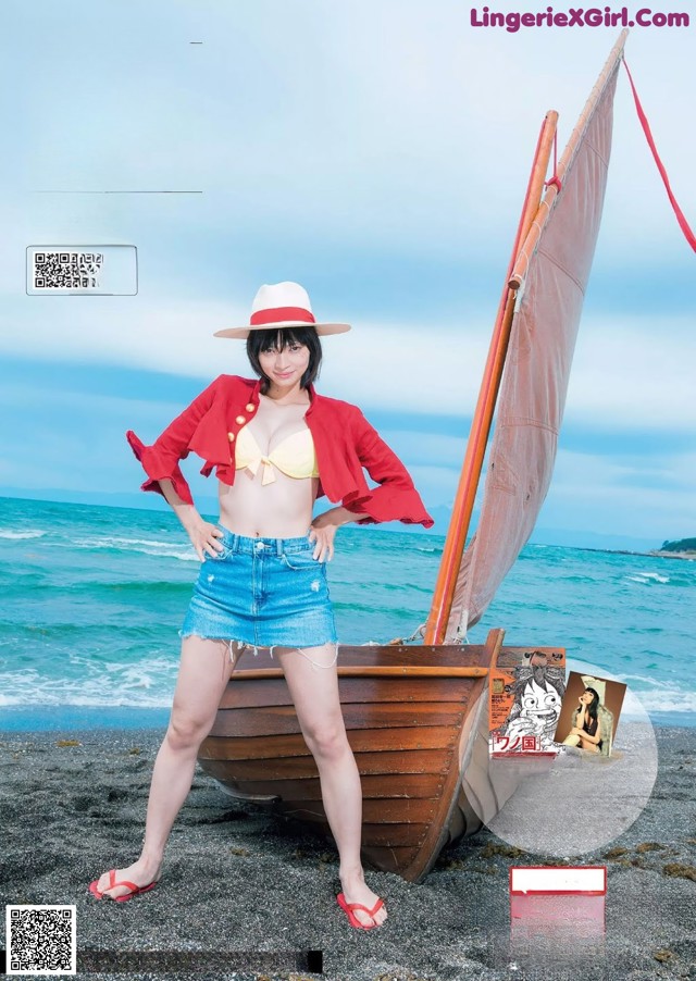 A woman in a bikini and hat standing next to a boat.