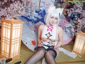 A woman in a white cat costume posing for a picture.