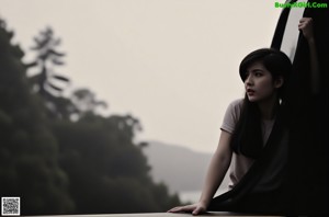 A woman sitting on a rock in the woods.