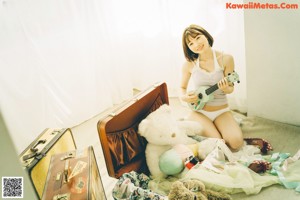 A woman sitting on top of a bed with her legs crossed.
