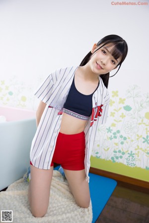 A woman in red shorts and a striped shirt posing for a picture.