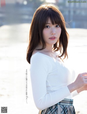 A woman in a pink sweater holding a cup of tea.