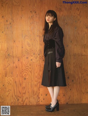 A woman sitting on a red chair in a room.
