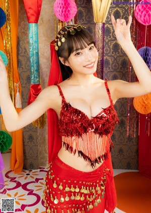 A woman in a green belly dance outfit posing for a picture.