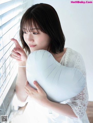 A woman sitting on the floor in front of a window.